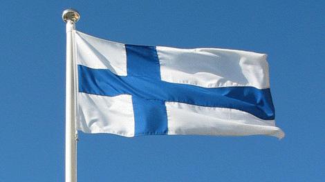 Suomen lippu liehuu sinistä taivasta vasten