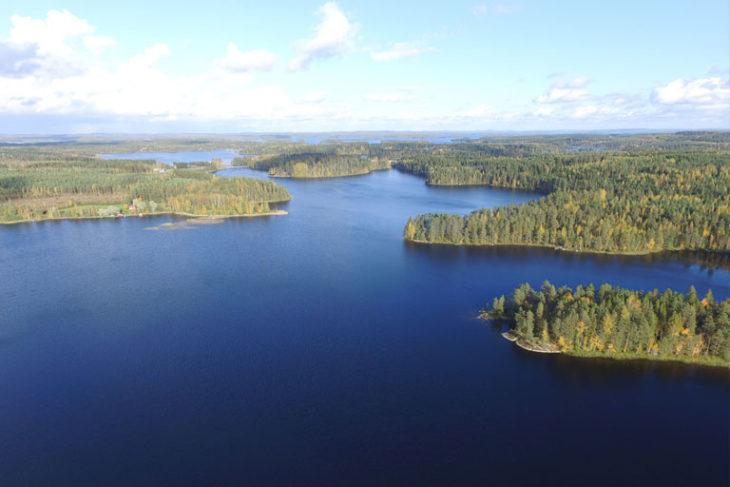 Ilmakuva aurinkoisella kesäsäällä sinisistä järvistä sekä vihreästä metsästä ja saarista.